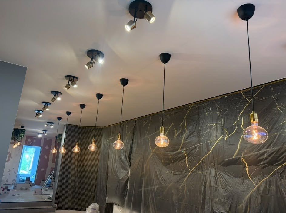 Plafond équipé de spots orientables et de suspensions à ampoules dorées